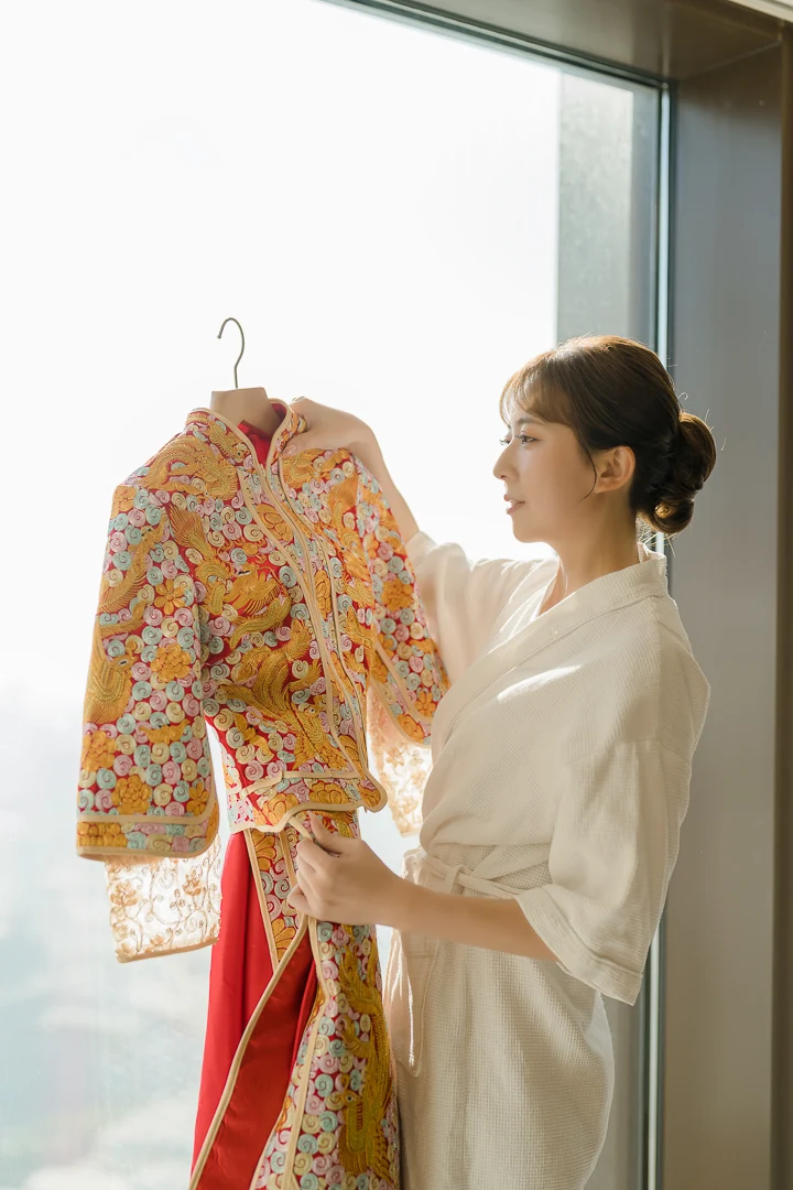 新娘在窗前拿起中式禮服